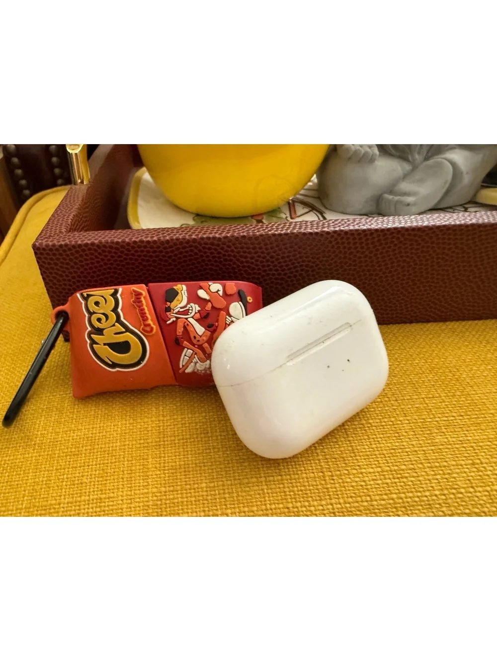 AirPods charger and half of a Cheetos case